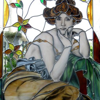 Vetrata con donna realizzata con tecnica a piombo ed inserti dipinti a grisaglia ispirata ad opere di Alfons Mucha